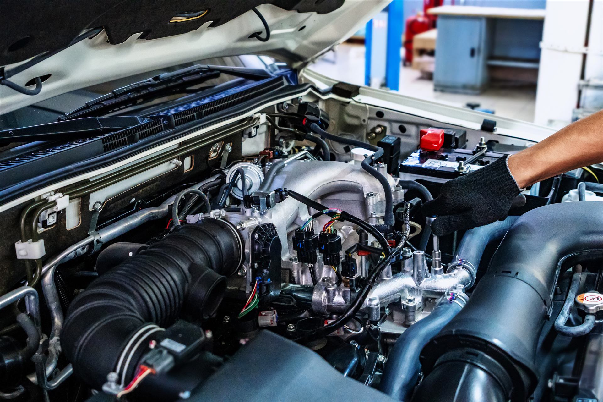 Mechaniker arbeitet unter der geöffneten Motorhaube
