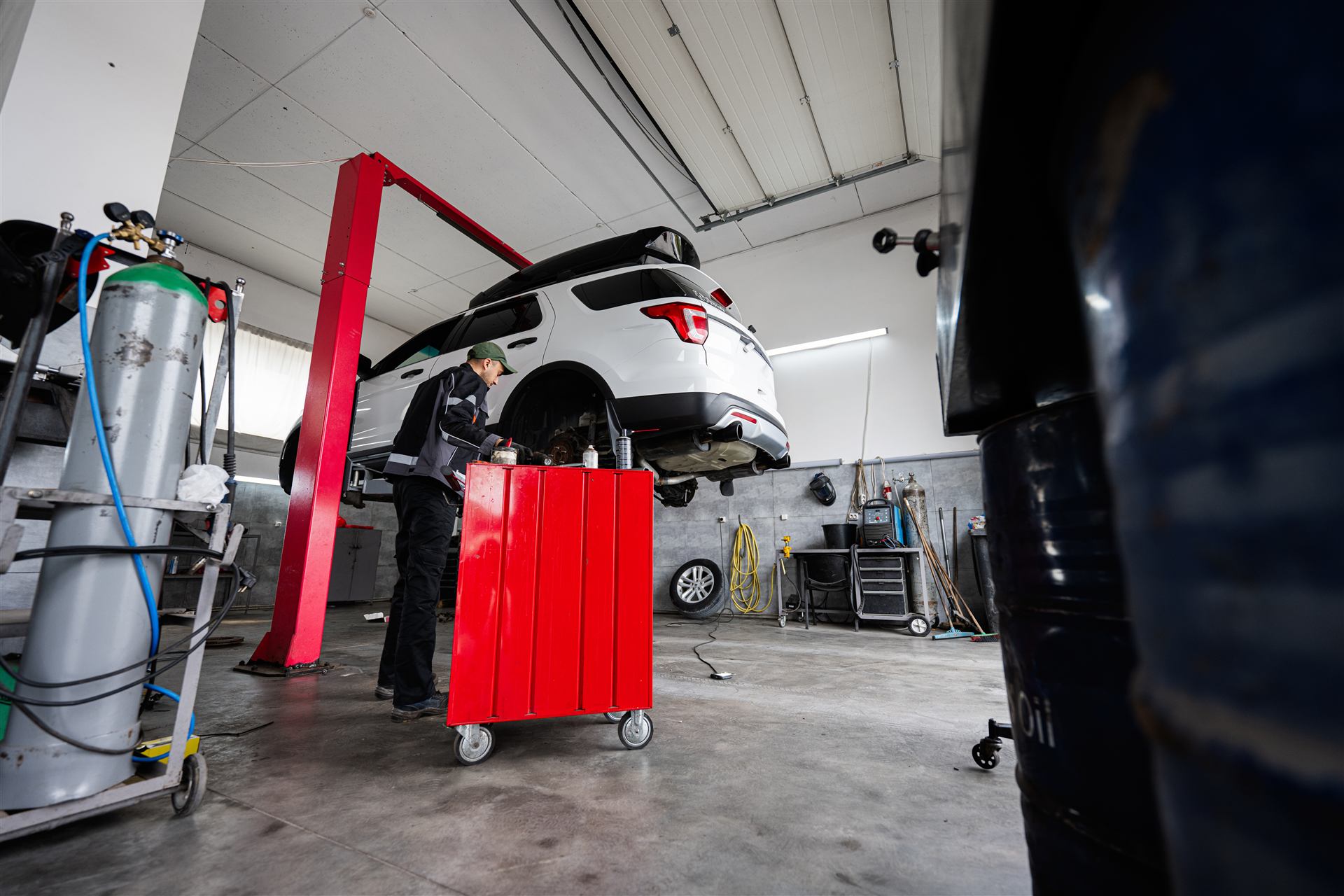 Demo-Webseite für eine KFZ-Werkstatt: Mechaniker arbeitet unter einem Auto auf der Hebebühne